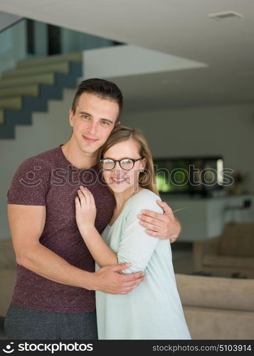 Portrait of a happy young beautiful couple hugging in their new home