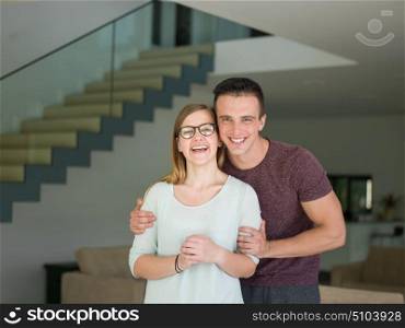 Portrait of a happy young beautiful couple hugging in their new home
