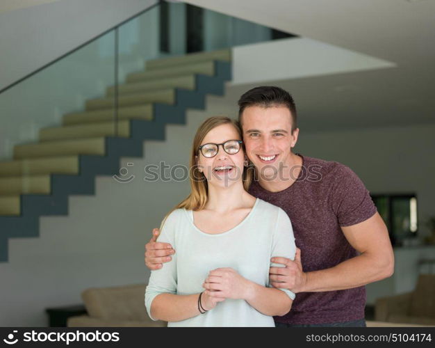 Portrait of a happy young beautiful couple hugging in their new home