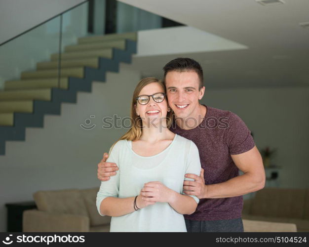 Portrait of a happy young beautiful couple hugging in their new home