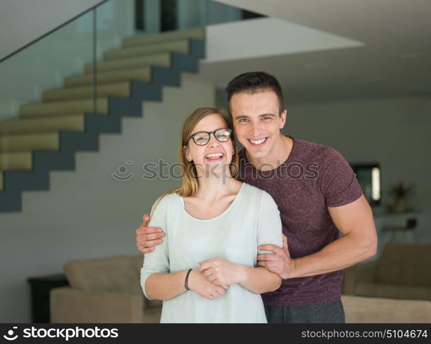 Portrait of a happy young beautiful couple hugging in their new home