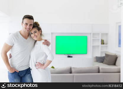 Portrait of a happy young beautiful couple hugging in their new home