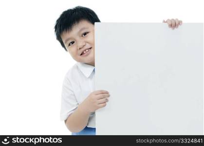 Portrait of a happy young boy holding a blank card over white background