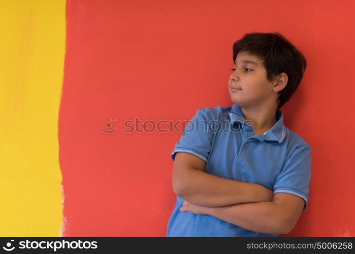 Portrait of a happy young boy in front of colored background