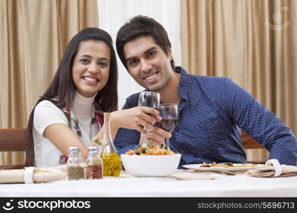 Portrait of a happy young couple having wine at restaurant