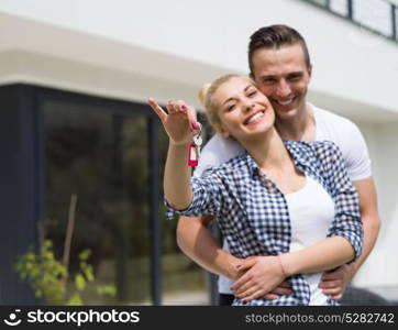 Portrait of a happy young couple hugging in front of their new luxury home villa