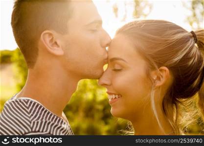 Portrait of a happy young couple in love and giving a kiss