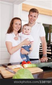 Portrait of a happy young family at home in the kitchen
