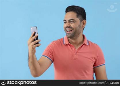Portrait of a happy young man enjoying with his Smartphone
