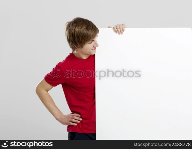 Portrait of a happy young man looking to a blank white card