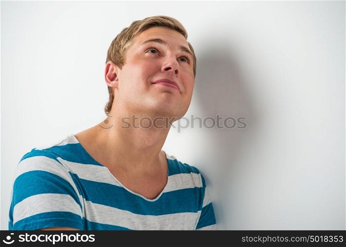 Portrait of a happy young man looking upwards in thought