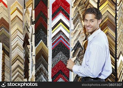 Portrait of a happy young man with multi colored frames in background