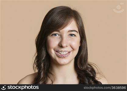Portrait of a happy young woman with sprinkled lips over colored background
