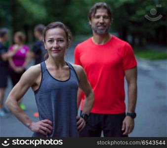 portrait of a healthy jogging couple. portrait of a healthy jogging couple with the rest of their running team in the background