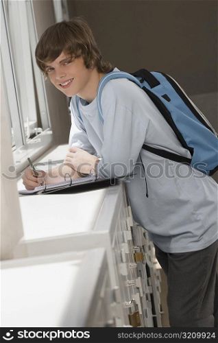 Portrait of a high school student writing in a ring binder