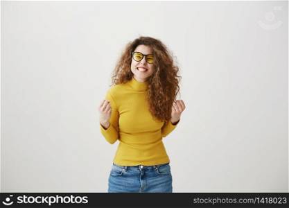 Portrait of a joyful happy teenage girl celebrating success while dancing isolated over gray background. Portrait of a joyful happy teenage girl celebrating success while dancing isolated over gray background.