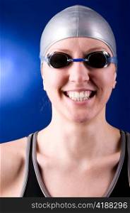 portrait of a laughing looking at camera woman swimmer on blue background