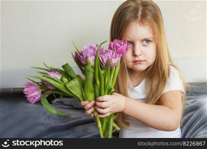 portrait of a litlle girl with bouquet of flowers tulips in her hands. portrait of litlle girl with bouquet of flowers tulips in her hands