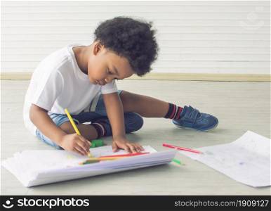 Portrait of a little african boy is drawing and painting while staying at home with copy space. Education Concept.