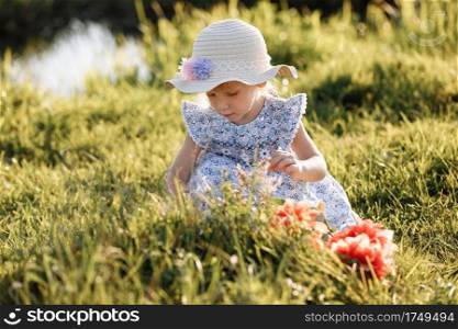 Portrait of a little beautiful girl on nature on summer day vacation. The playing in the park at the sunset time. Close Up. The concept of family holiday and time together. Portrait of a little beautiful girl on nature on summer day vacation. The playing in the park at the sunset time. Close Up. The concept of family holiday and time together.