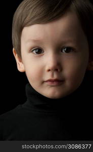 portrait of a little boy on a dark background. portrait of a little boy