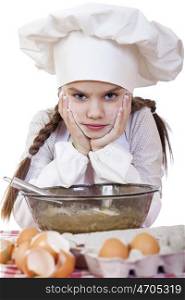 Portrait of a little girl in a white apron and chefs hat knead the dough in the kitchen, isolated on a white background