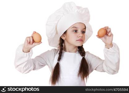 Portrait of a little girl in a white apron holding two chicken eggs, isolated on white background