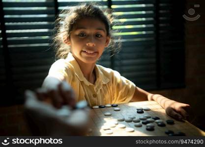 Portrait of a little girl in office room of house with a game of Go being learned to build concentration and intelligence.