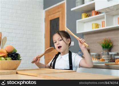 Portrait of a little girl in the kitchen of a house having fun playing with fruit toy and kitchenware
