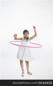 Portrait of a little girl twirling hoop around waist