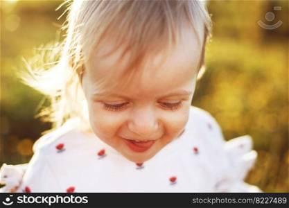 portrait of a little happy girl outdoor . the child smiles and shows the tongue