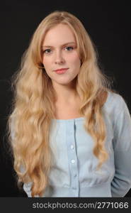 Portrait of a long-haired beautiful young woman on black background