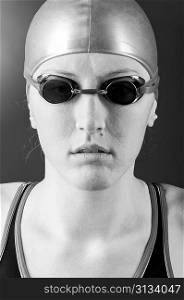 portrait of a looking at camera woman swimmer on blue background