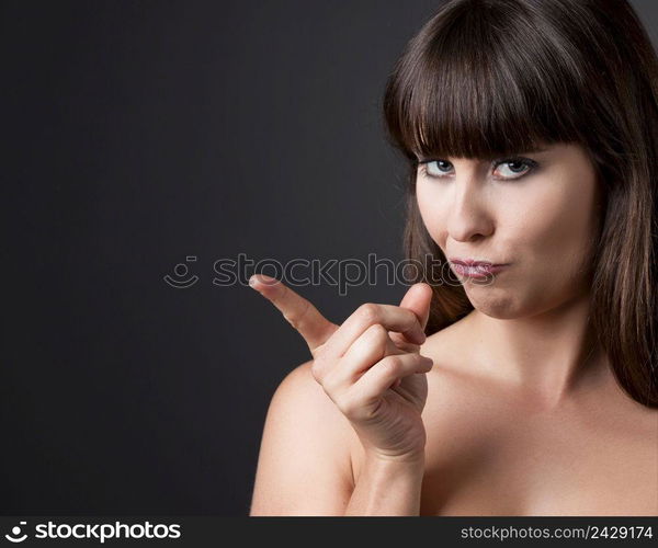 Portrait of a lovely and confident woman smiling against a grey background 