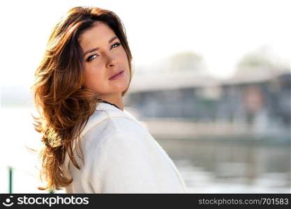 Portrait of a lovely sensual woman posing outdoor by the river on a sunny autumn day ( copy space)