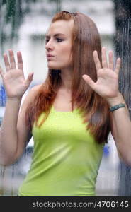 Portrait of a lovely young lady looking through glass window