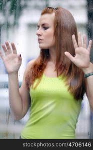 Portrait of a lovely young lady looking through glass window