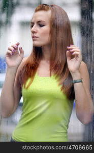 Portrait of a lovely young lady looking through glass window