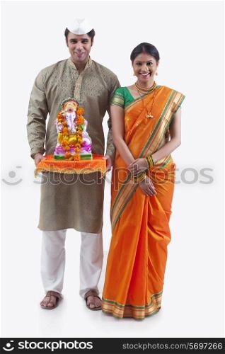 Portrait of a Maharashtrian couple with a Ganesh idol