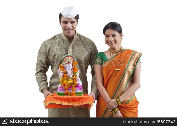 Portrait of a Maharashtrian couple with a Ganesh idol