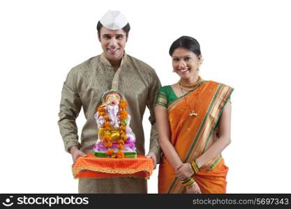Portrait of a Maharashtrian couple with a Ganesh idol
