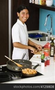 Portrait of a maid preparing food in the kitchen and smiling