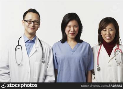 Portrait of a male and a female doctor with a female nurse standing side by side