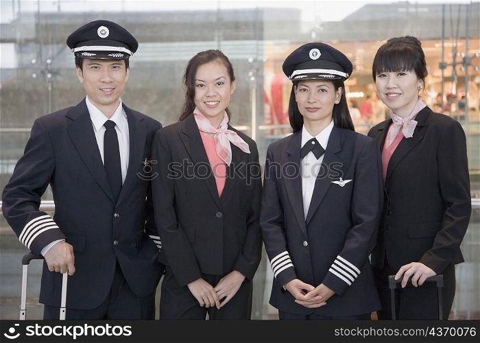 Portrait of a male and a female pilot standing with two female cabin crews