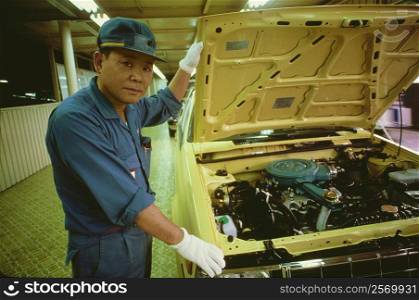 Portrait of a male auto mechanic repairing a car, Zama, Kanagawa Prefecture, Japan