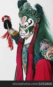 Portrait of a male Chinese opera performer holding a weapon