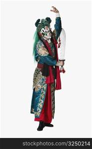 Portrait of a male Chinese opera performer standing holding a sword