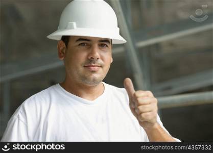 Portrait of a male construction worker showing a thumbs up sign