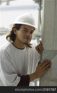 Portrait of a male construction worker using a set square