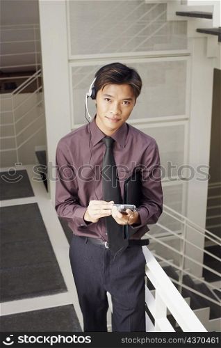 Portrait of a male customer service representative holding a file and a mobile phone